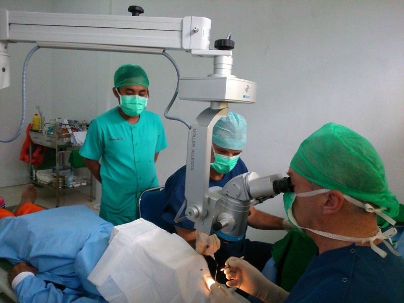 Artsen operend aan oog met microscoop